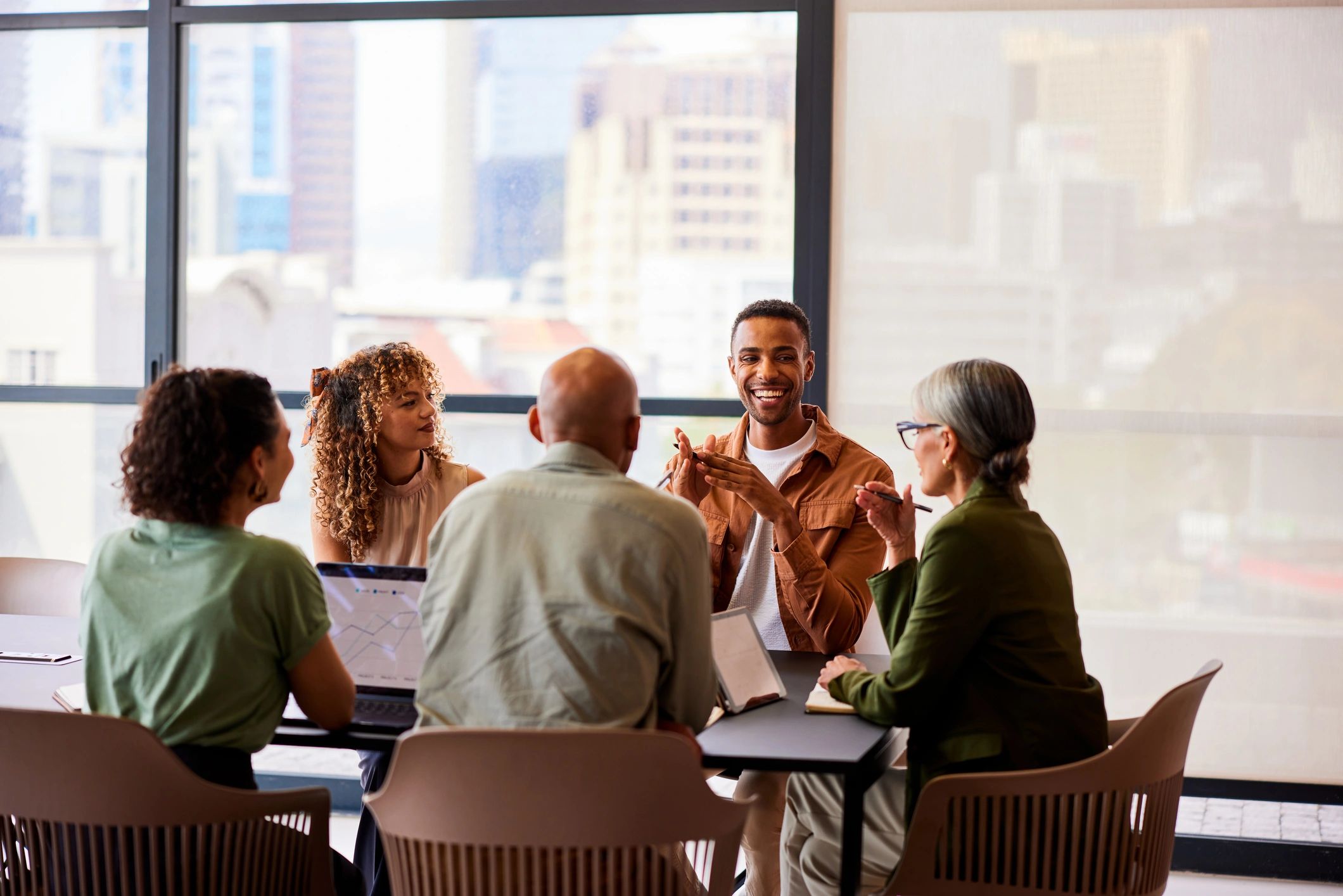 Equipe em reunião analisando informações em dispositivos